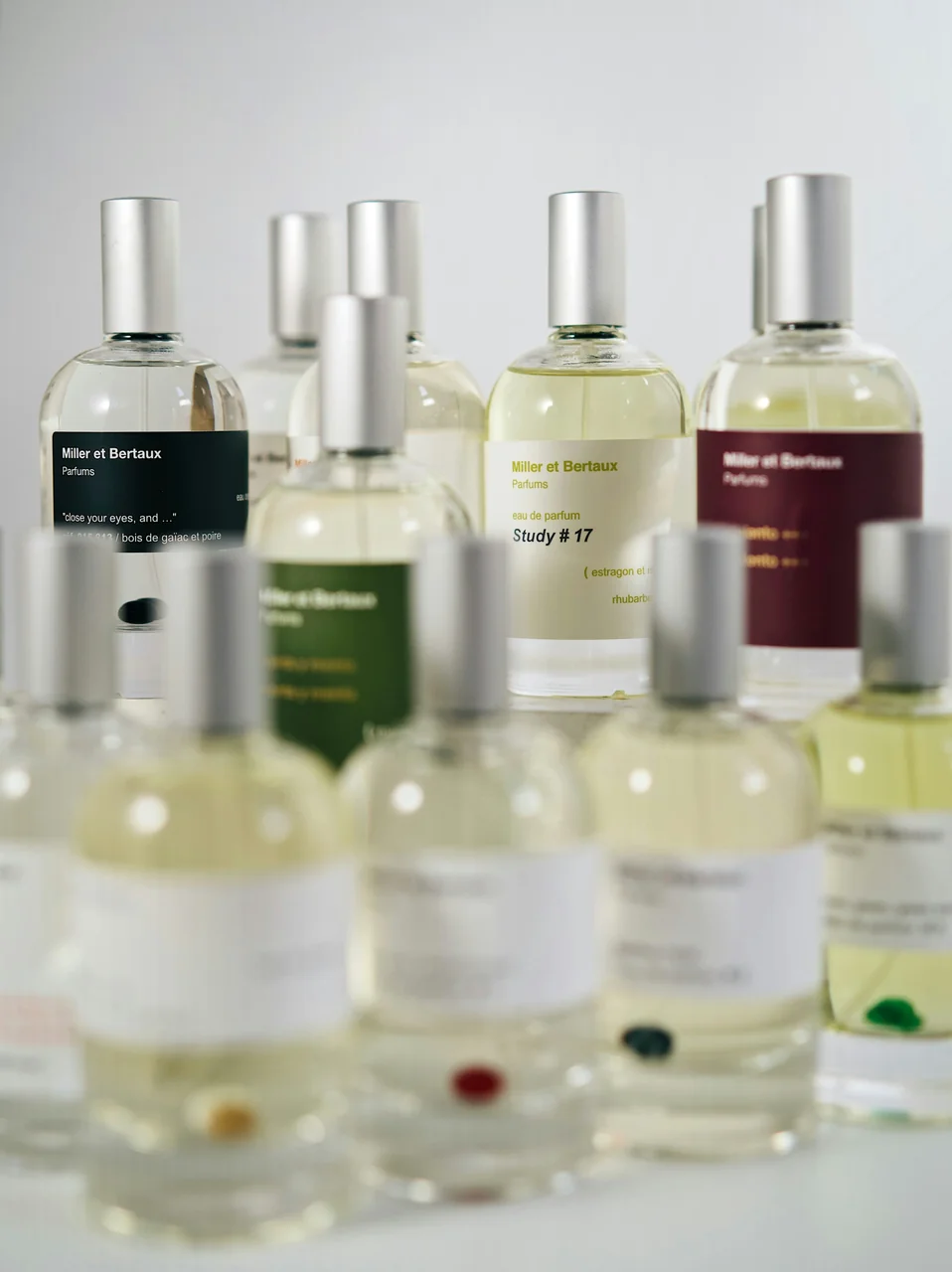 Lineup of niche perfume bottles on a neutral surface — curated 2026 trend still life