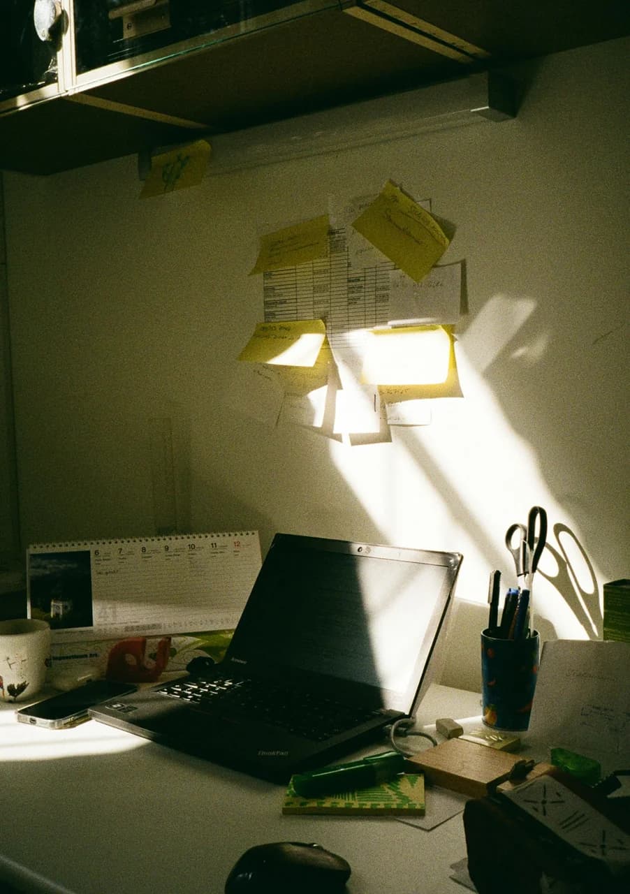 Desk with sticky notes, calendar, and notebook in natural sunlight — quiz methodology mood
